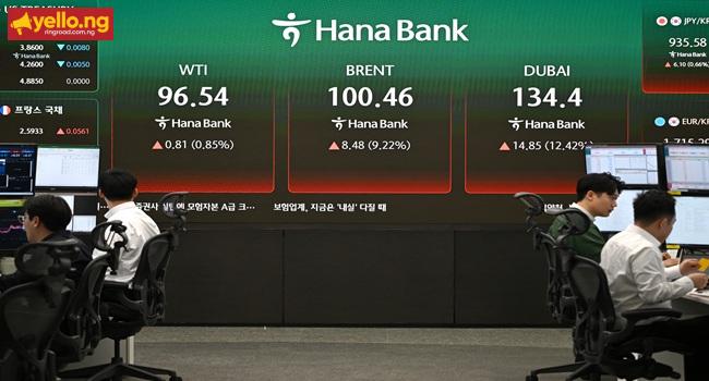 Currency dealers monitor exchange rates as an electronic screen shows the prices of WTI (L), Brent crude (C) and Dubai crude (R) in a foreign exchange dealing room at the Hana Bank headquarters in Seoul on March 13, 2026. (Photo by Jung Yeon-je / AFP)